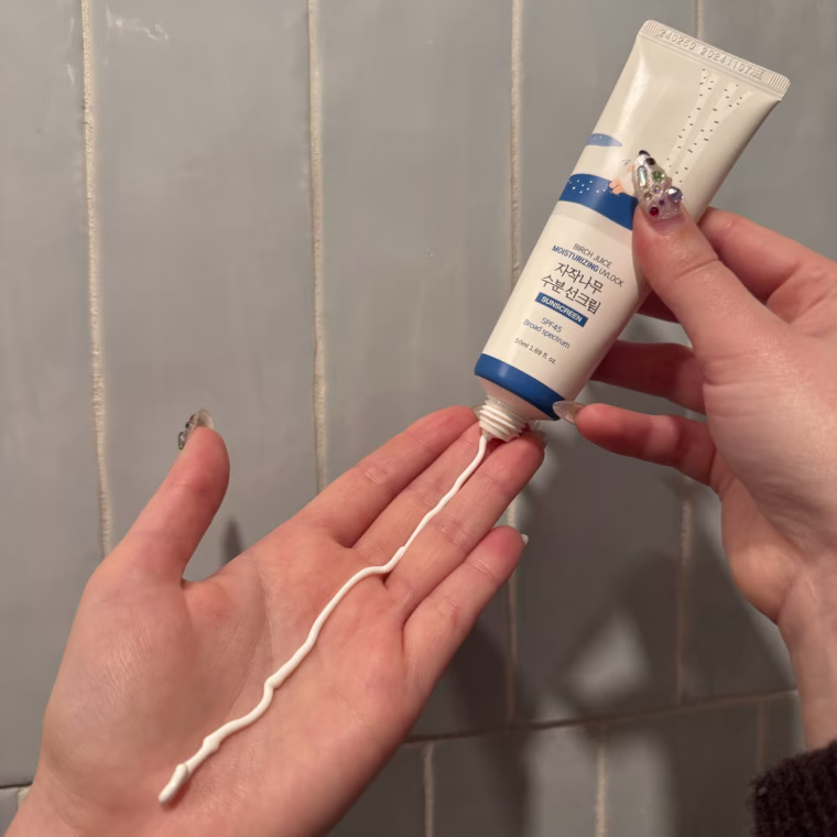 Woman dispensing sunscreen on palm