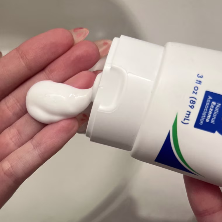 Woman dispensing cream on her hands.