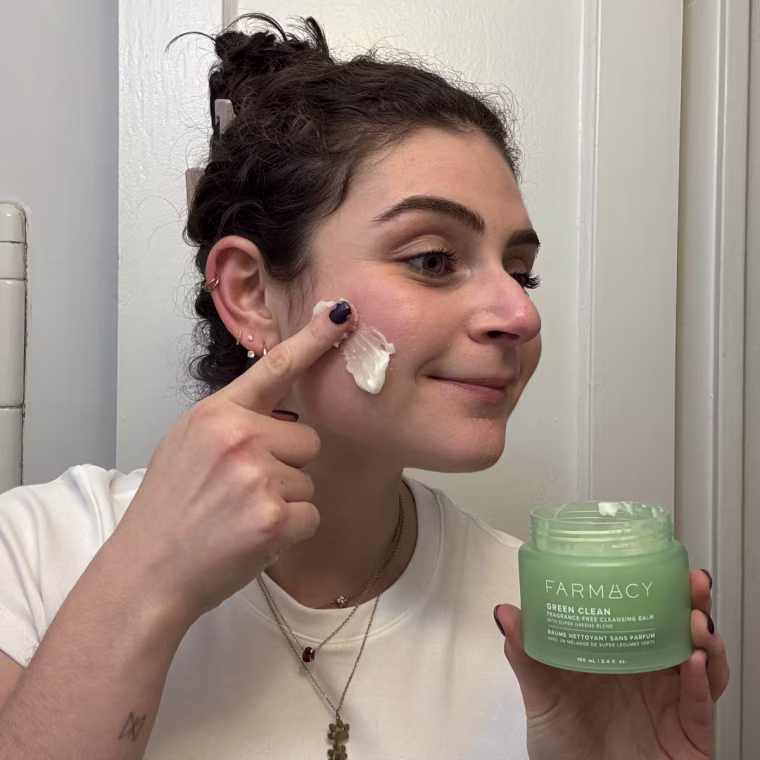 Woman applying cleansing balm to her face