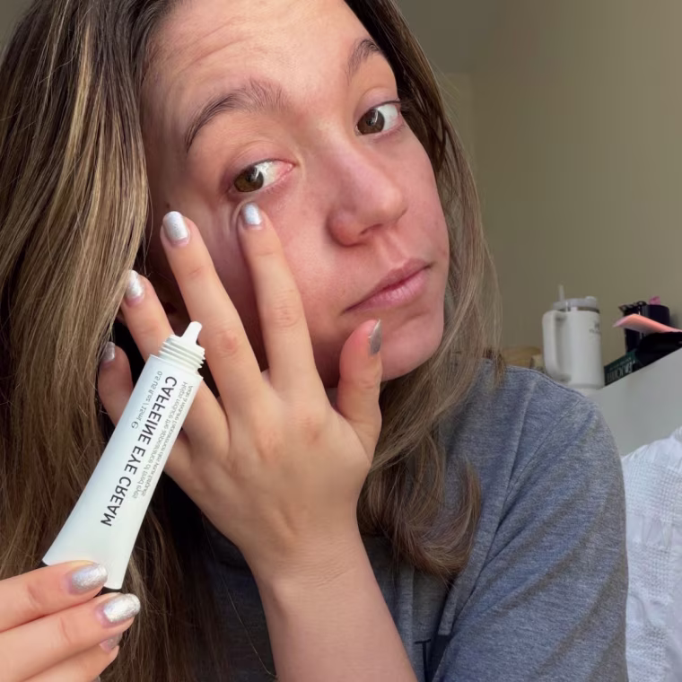 Woman applying eye cream.
