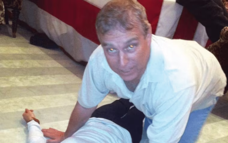 A photograph from an Epstein document release appears to show then-Prince Andrew kneeling over an unknown female.