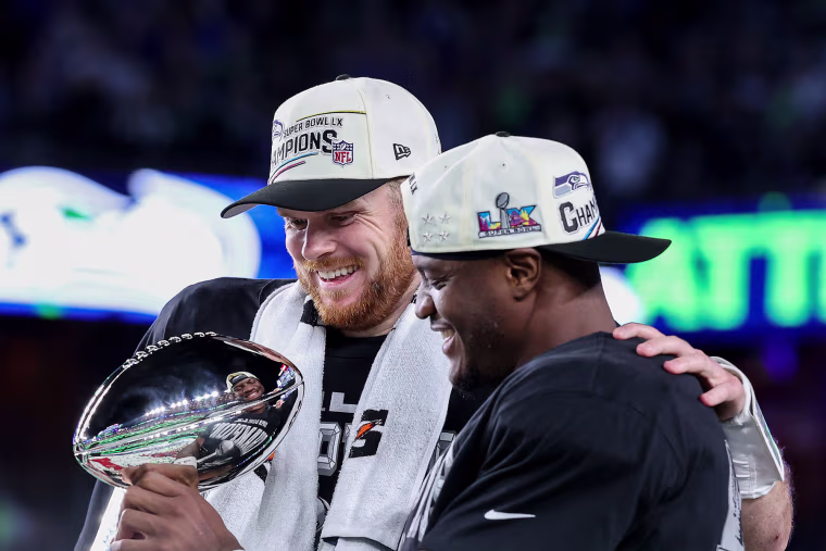 Sam Darnold #14 and Kenneth Walker III #9 of the Seattle Seahawks celebrate with the Vince Lombardi Trophy