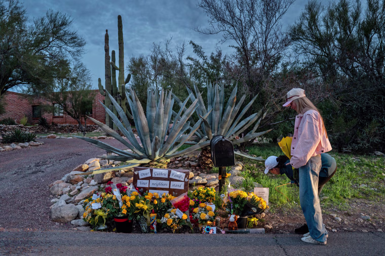 People stop at a makeshift memorial at the entrance to Nancy Guthrie's home on Feb. 12, 2026 in Tucson, Ariz.