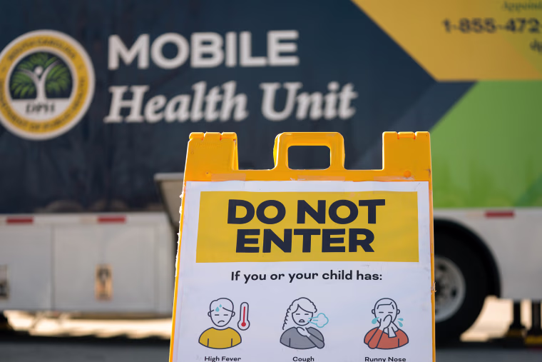A sign reads DO NOT ENTER with graphic illustrations of people experiencing illness.
