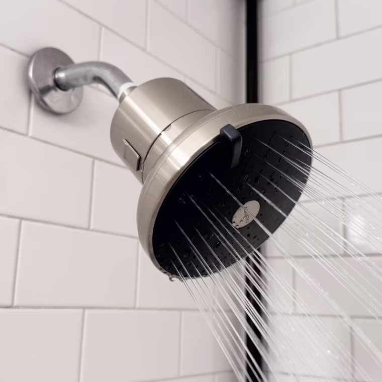 A silver AquaTru filtered showerhead installed in a bathroom.