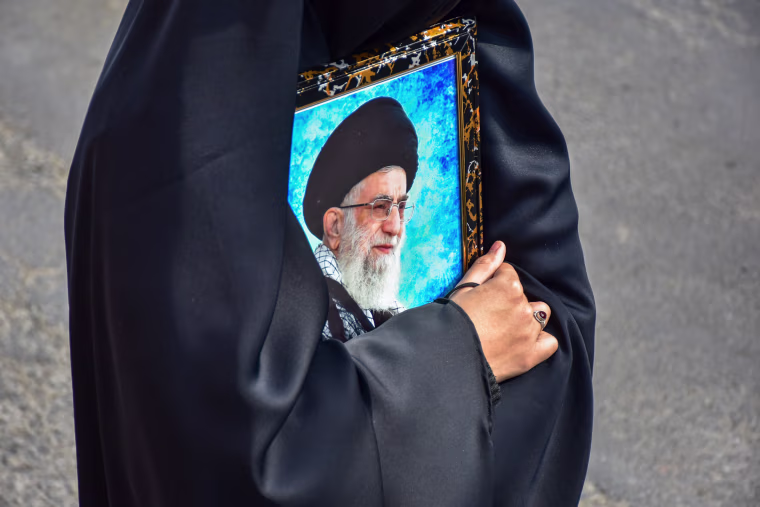 A Kashmiri Shiite Muslim protester holds a photograph of the