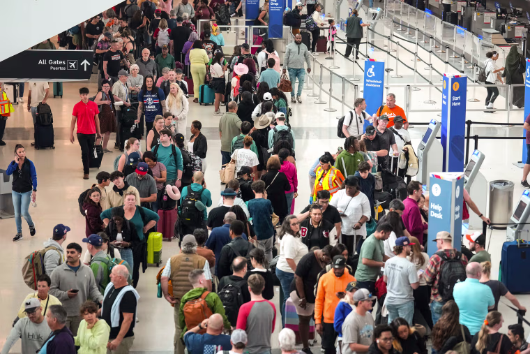 An elevated view of throngs of people in an airport terminal.