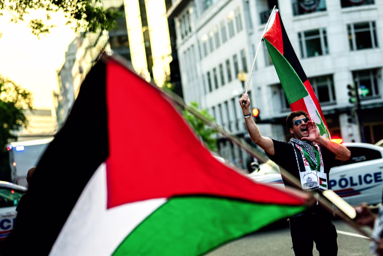 A man holds a Palestinian flag outside