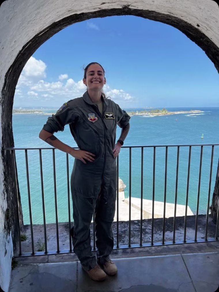 Ariana G. Savino smiles in a portrait outside on a balcony overlooking the water