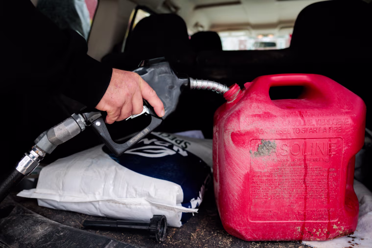 Roy Strohecker fills a red gas cannister