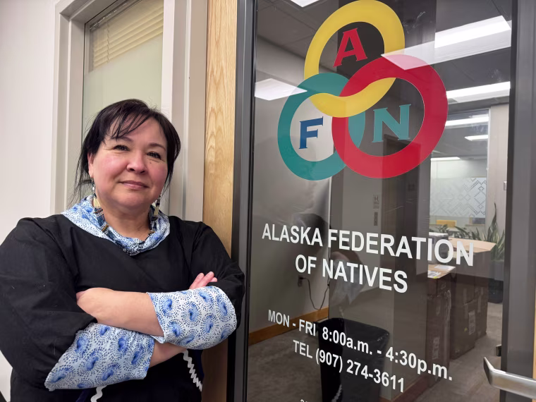 Michelle Sparck poses for a portrait against a door frame leading to Alaska Federation of Natives