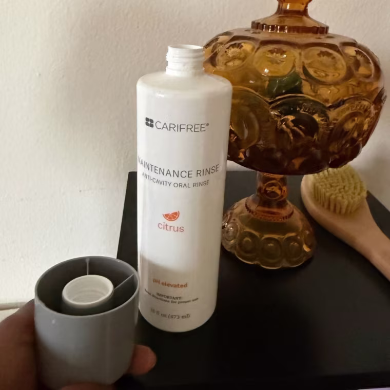 White bottle of Carifree mouthwash on a black desk.