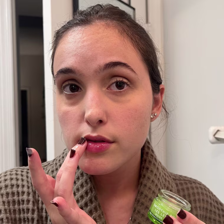 Woman applying lip serum to lips