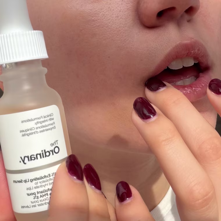 Woman applying lip serum to lips