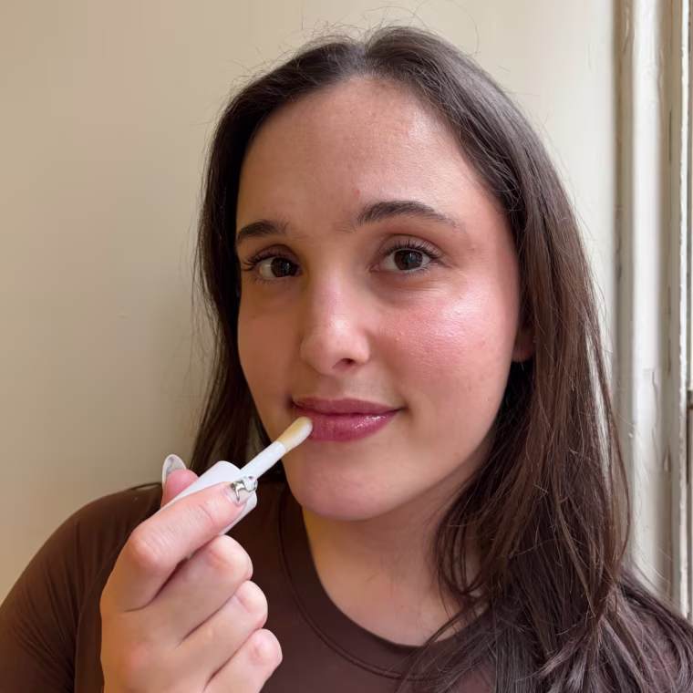 Woman applying lip oil to lips
