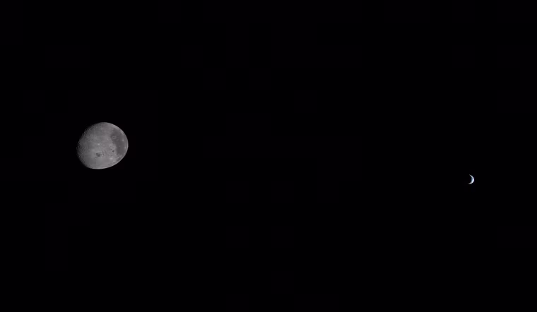 The moon and Earth each partially illuminated by the sun as seen from the Orion spacecraft on April 6, 2026.
