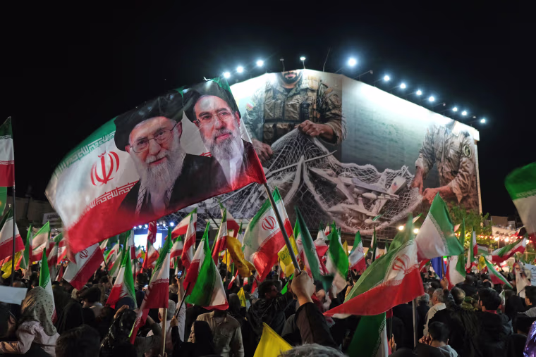 Iranians rally under a huge banner proclaiming that the Strait of Hormuz will remain closed