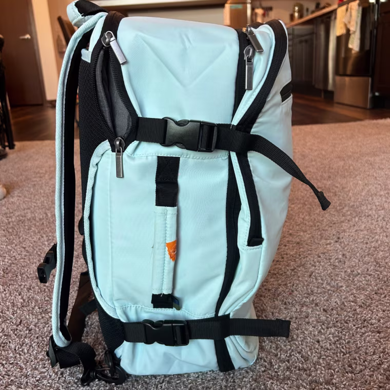 The buckled straps help compress the Open Story carry-on backpack so it can easily fit in an overhead bin.