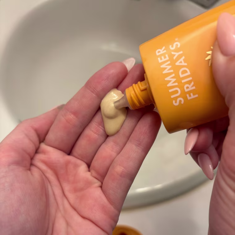 Woman squeezing sunscreen on hand