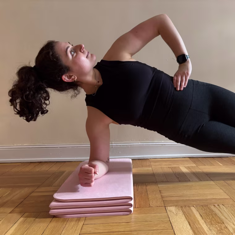 Woman doing side plank on Stakt mat