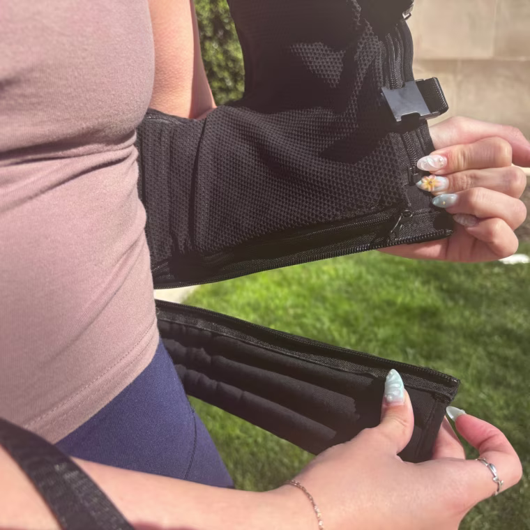 Woman holding removable panel on weighted vest