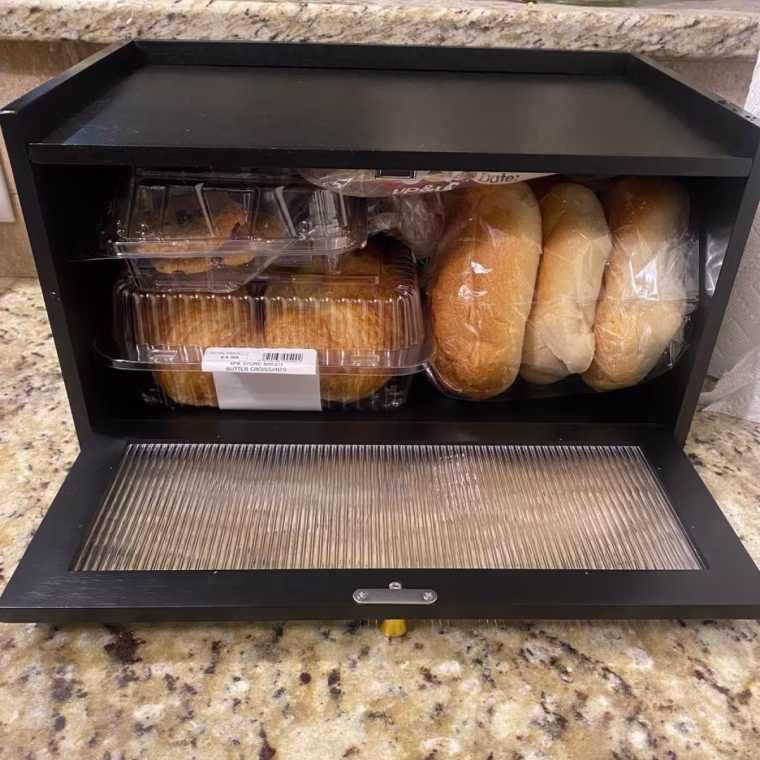 Bread box holding various bagels and breads.
