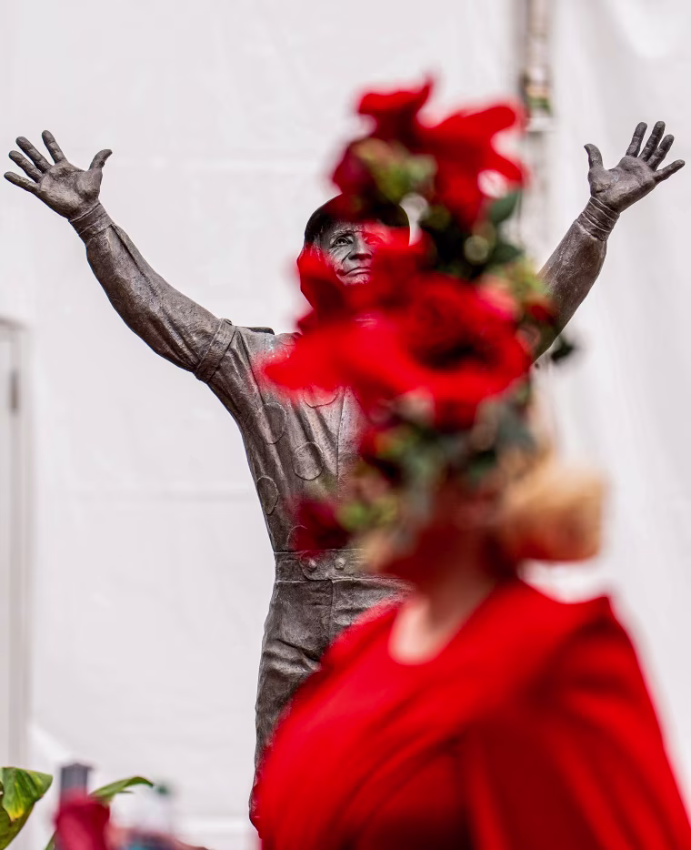 Race fans pass by the Pat Day statue.