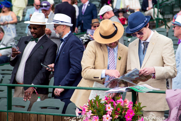 Attendees check racing forms of the prep races.