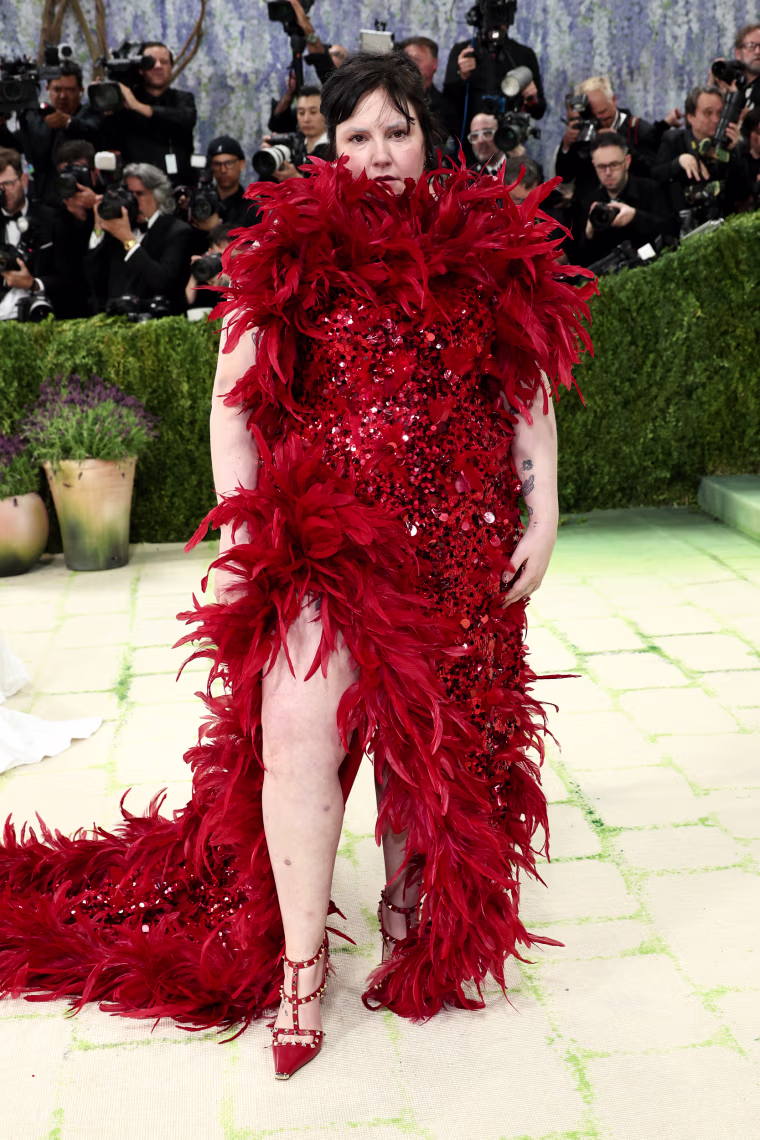 Lena Dunham in a red feathered dress.