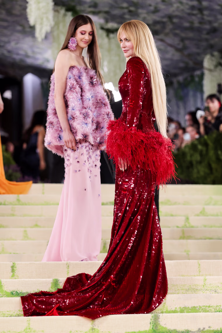 Nicole Kidman wears a sparkly red sequin dress, right, and Sunday Rose Kidman wears a puffy pink dress on the white carpet