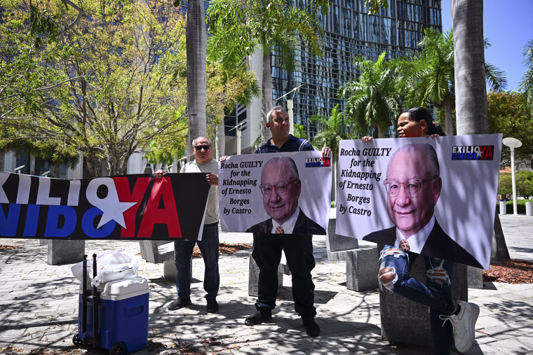 Protesters demanding the "maximum sentence" for former U.S. Ambassador to Bolivia, Victor Manuel Rocha, accused of spying for Cuba, outside court in Miami in 2024.