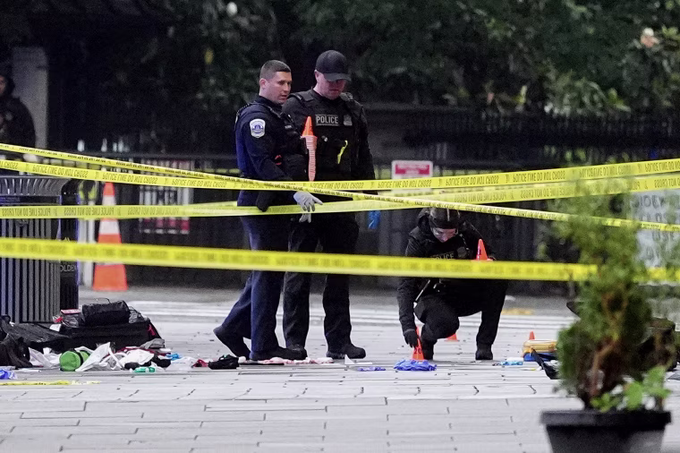 Yellow Crime scene tape stretches across the frame in front of police officers.