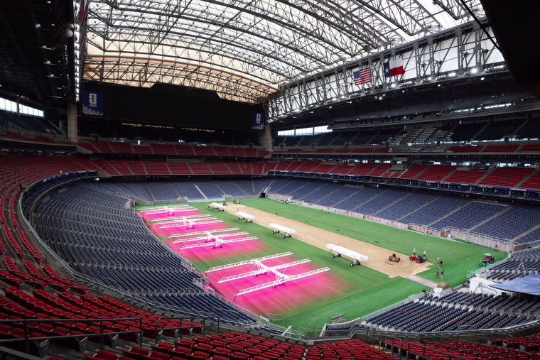 An interior view of NRG Stadium, the astroturf is being sprayed with a pink substance
