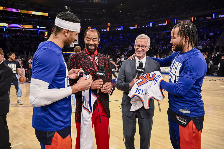 Josh Hart and Jalen Brunson of the New York Knicks congratulate Walt Frazier and Mike Breen.