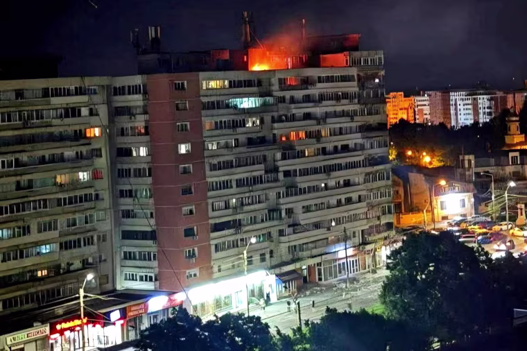 Fire burns on the roof of a 10-story block of flats after a drone crashed into the building in Galati