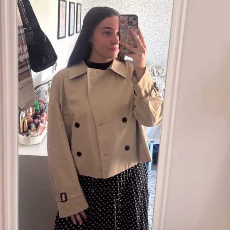 A woman standing in mirror wearing Aritzia The Esquire Short Trench Coat