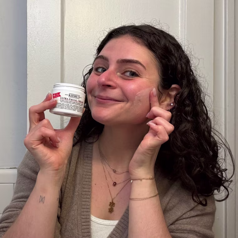 A woman applying Kiehl’s Ultra Facial Cream.