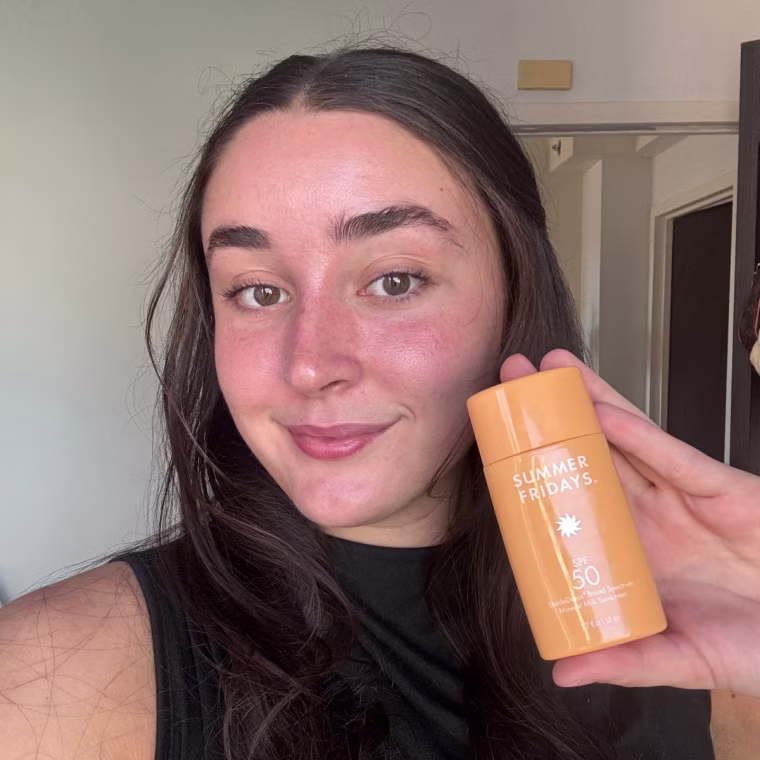 A person Holding up Summer Fridays ShadeDrops Broad Spectrum SPF 50 Mineral Sunscreen.