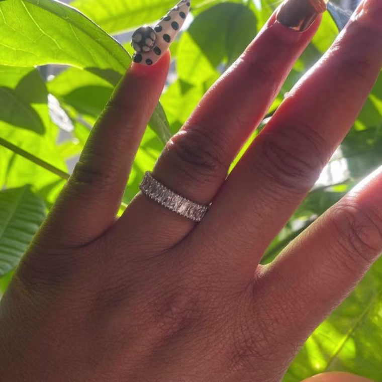 Photo of woman’s hand wearing crystal ring
