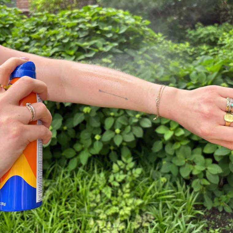 A woman applying Banana Boat’s Ultra Sport SPF 30 Sunscreen Spray.