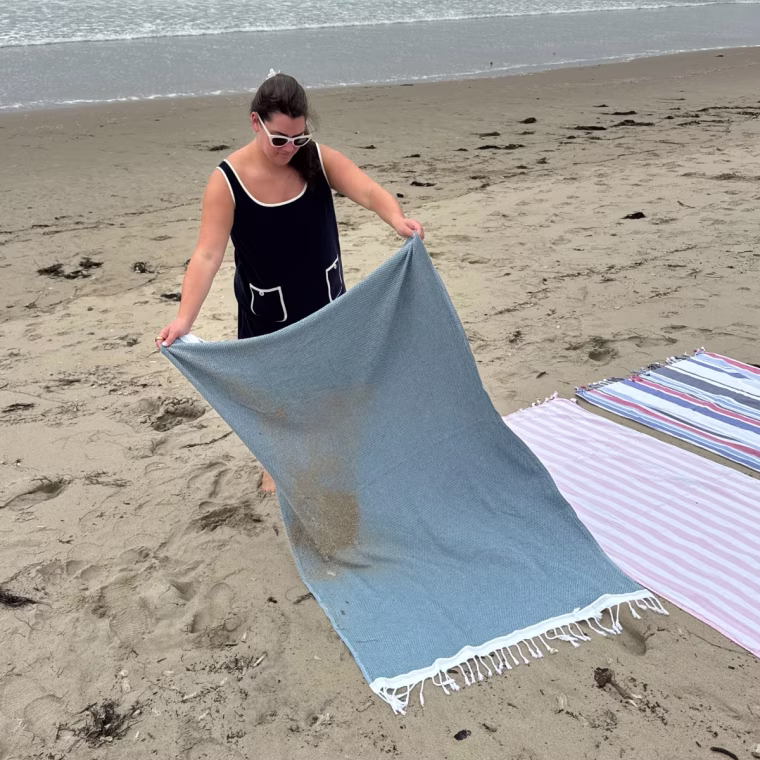 Clearing the sand off of the Coyuchi Turkish beach towel.