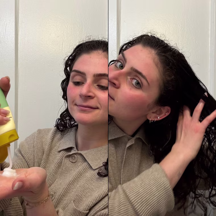Woman squeezing the Narka Hair Milk out of the bottle and applying it to the right side of her hair.