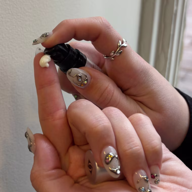 Woman applying a dot of lip cream on her finger