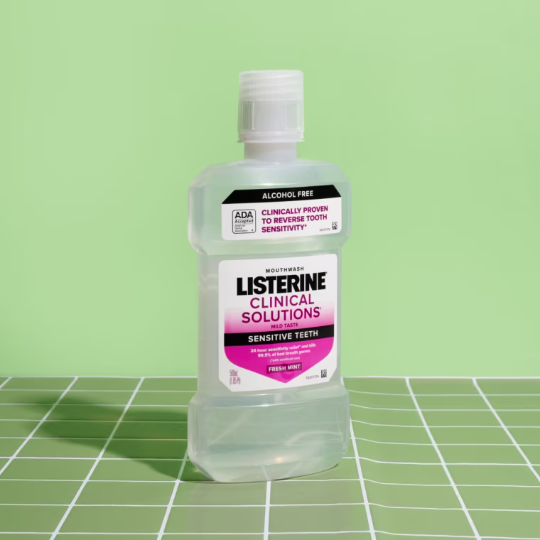 A large bottle of Listerine mouthwash on a tiled background.