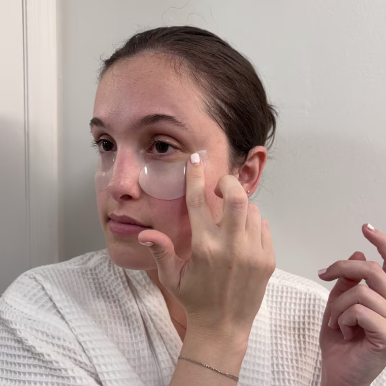 Woman applying patches under her eyes