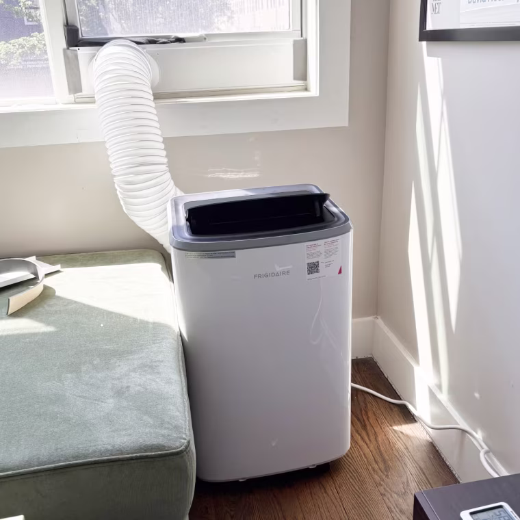 The Frigidaire portable AC is a bit larger than some units, but still fits snugly in this corner.