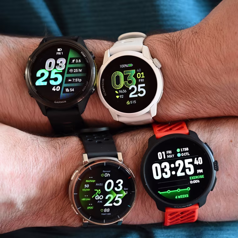 A close up of four different running watches on the wrists of the writer.