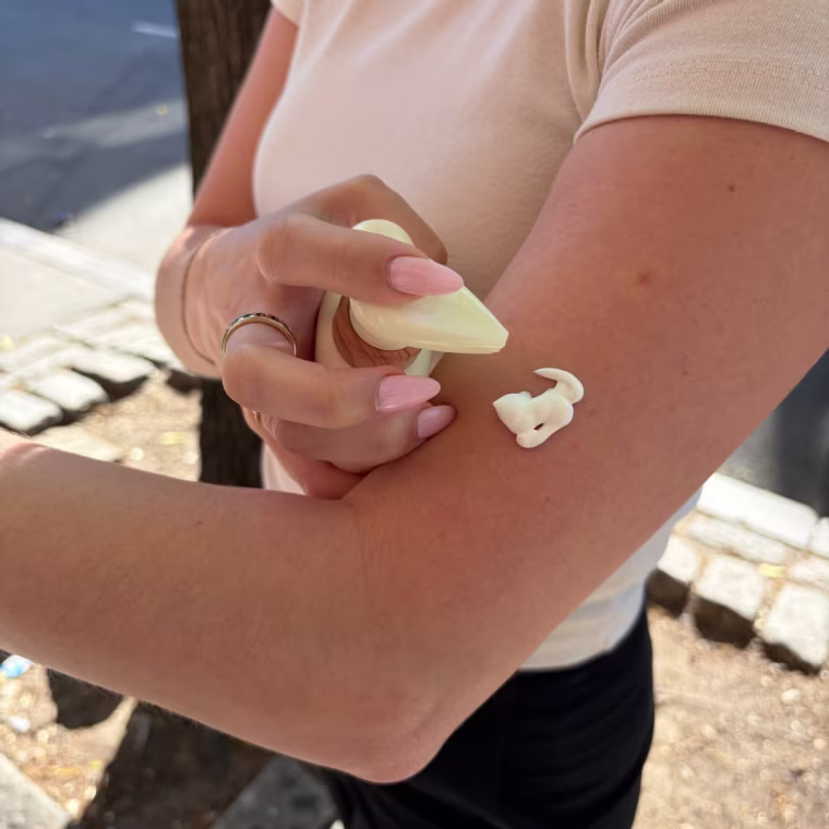 Woman applying sunscreen on arm