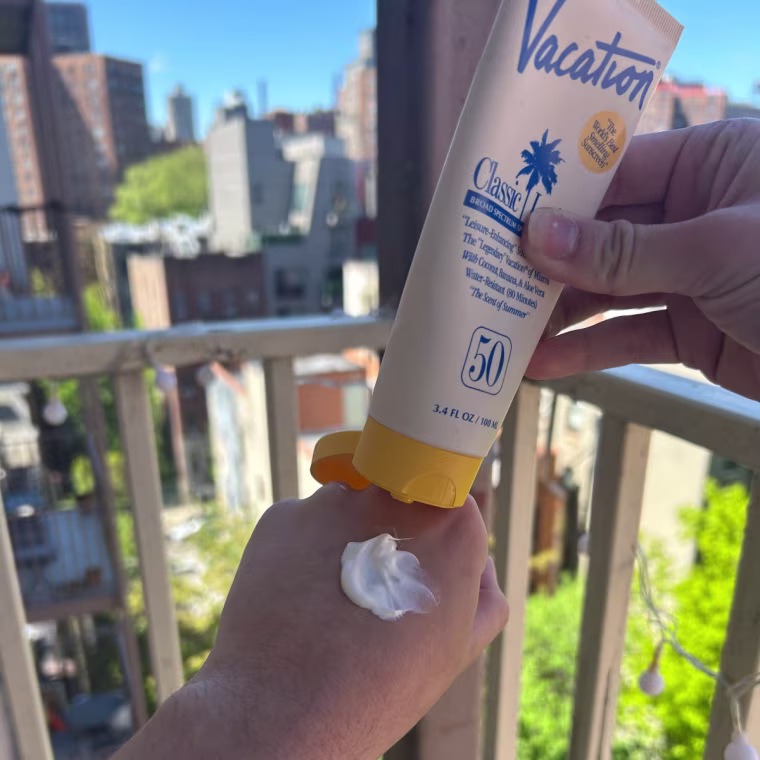 Woman applying Vacation body sunscreen to back of hand