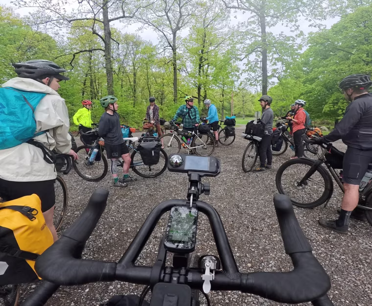 A group of cyclists with their bikes, standing in a rough circle.